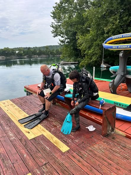 Coach McCain briefing a student on the dock before a dive